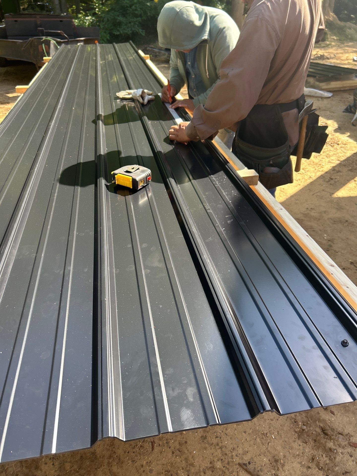 Metal roof installers measuring cuts