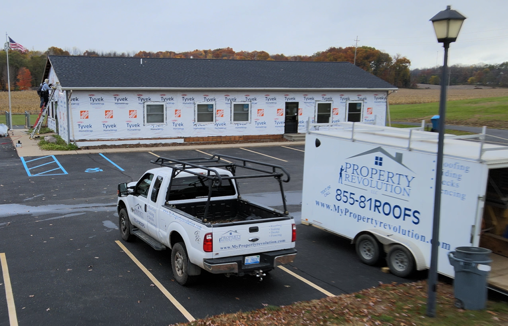 Property revolution working on a siding and roofing job